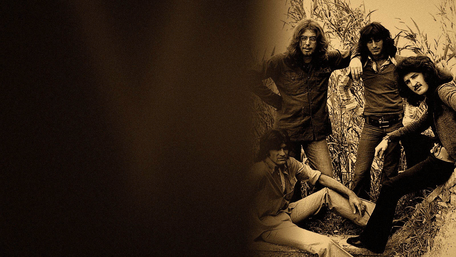 I New Trolls in una foto promozionale degli anni Settanta: quattro musicisti in posa fra alte canne, in un bianco e nero virato all'ambra